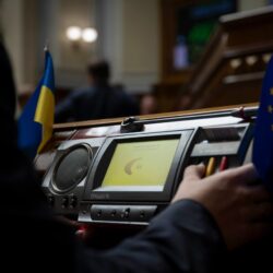 Солдат у військовій формі на фоні українського прапора