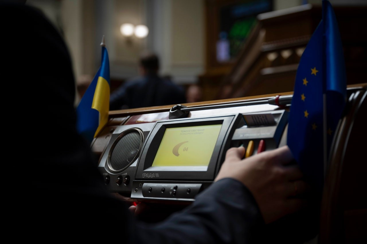 Солдат у військовій формі на фоні українського прапора